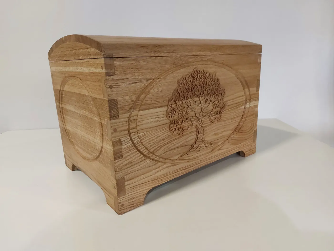 Tree-of-life oak chest, three-quarter view, made in our Riga workshop